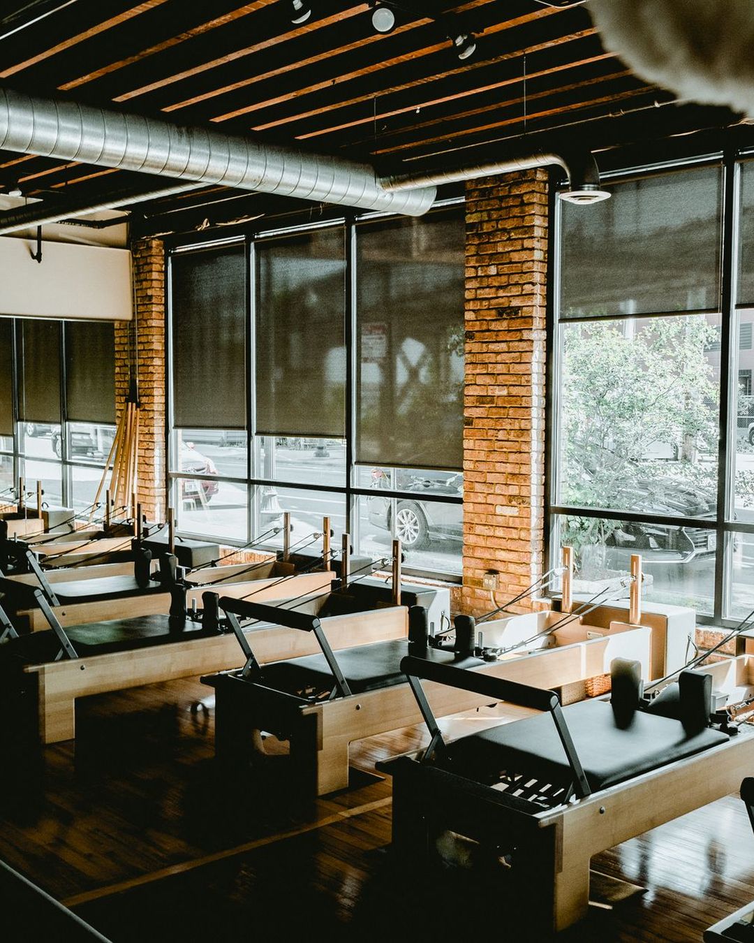 Studio de Pilates baigné de lumière naturelle avec ses Reformers.