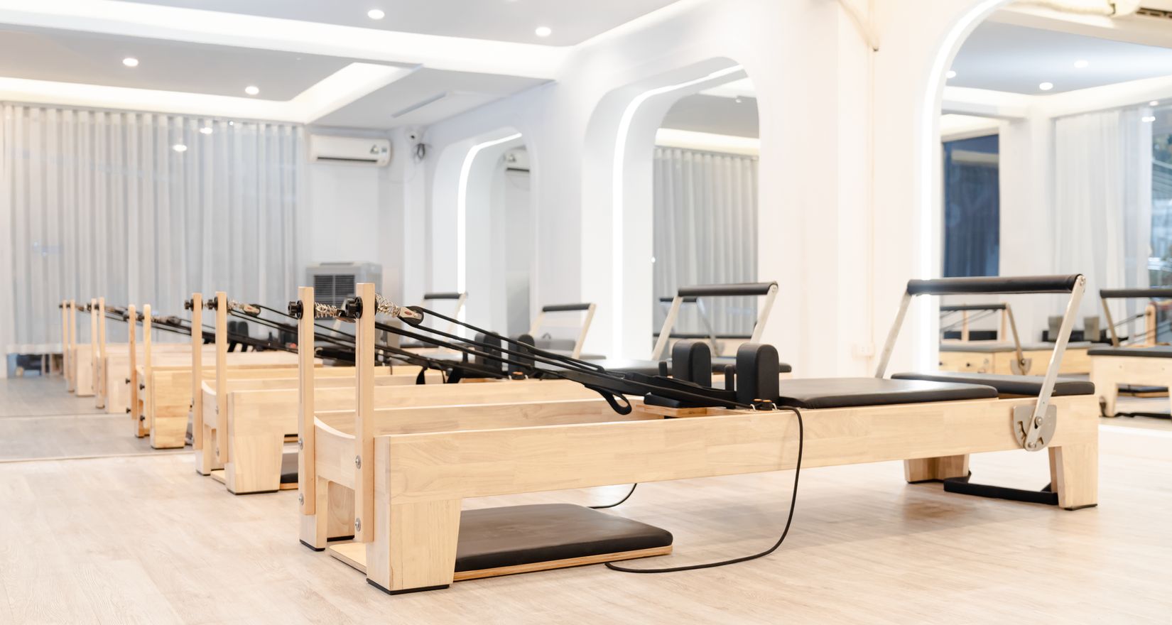 Studio de Pilates spacieux et minimaliste équipé de Reformers en bois.