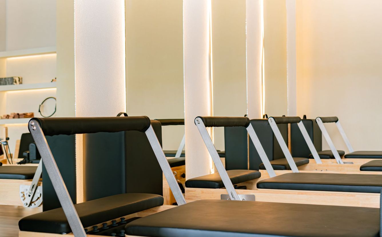 Studio de Pilates moderne avec plusieurs Reformers alignés.